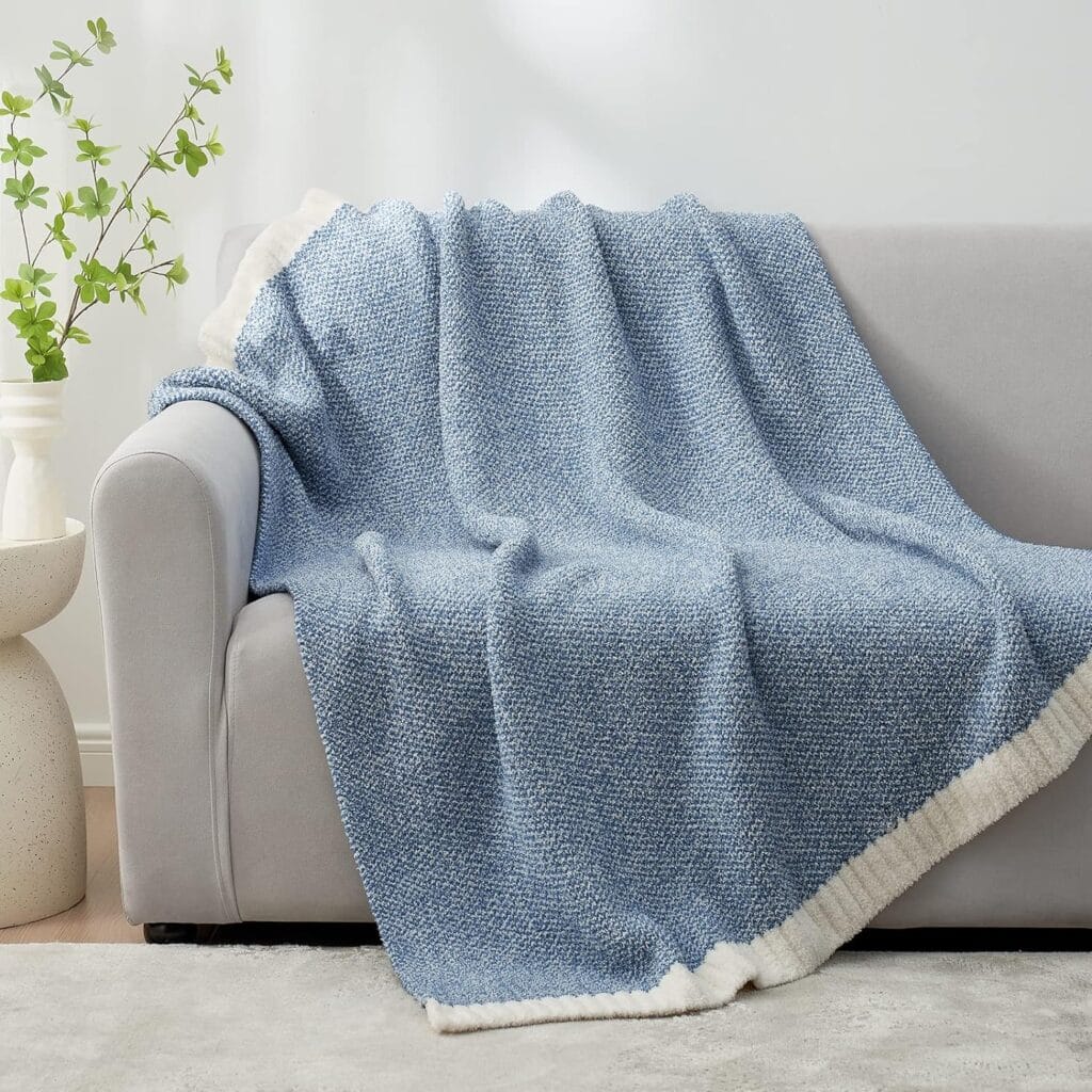 Photo of a blue woven throw blanket draped over the back and seat of a couch.