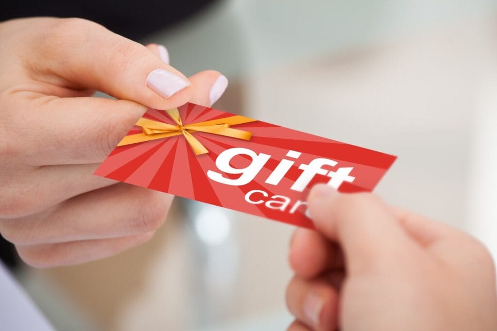 Image of a hand passing a generic gift card to another hand.