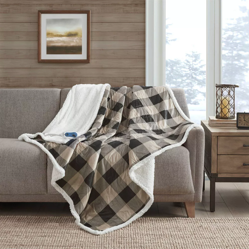Image of a soft heated blanket draped over the back and seat of a couch.