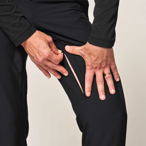 Image of a person using the inseam zipper along the inside of the thigh of a pair of Joe & Bella pants.