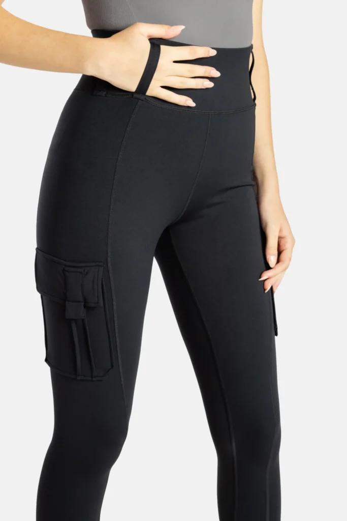 Image of a woman wearing a pair of No Limbits leggings with her hand slipped through the large waistband loops that make them easier to pull on.