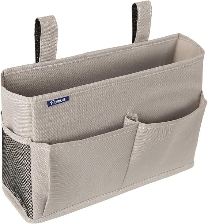Product image of the Surblue Bedside Caddy. It shows the velcro handles that can attach to a bedframe with one wide pocket, two smaller pockets on the front, and a mesh pocket on the side.